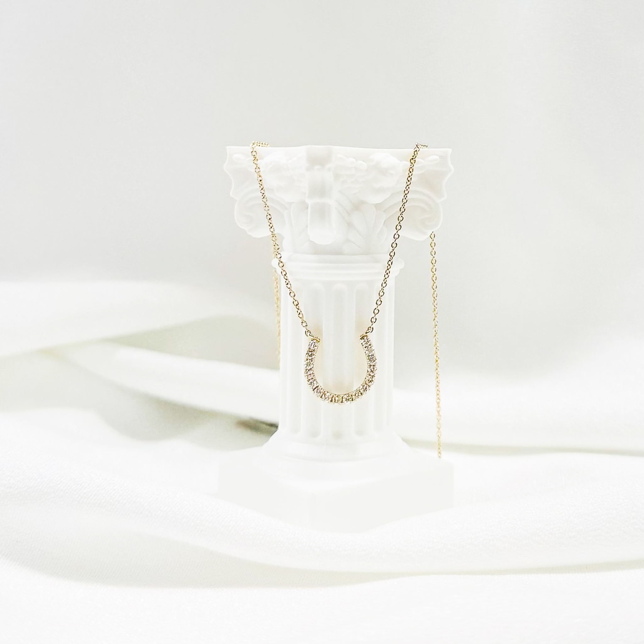 Gold horseshoe pendant necklace with diamond accents for good luck